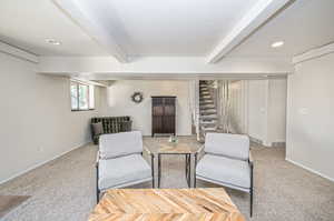 Sitting room with carpet, a textured ceiling, and beam ceiling