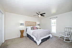 Primary Bedroom featuring a textured ceiling, carpet, and ceiling fan