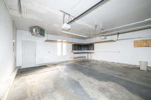 2 car Garage featuring garage door openers, built in cabinets and work bench