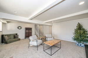 Sitting room with beamed ceiling, carpet, and a textured ceiling