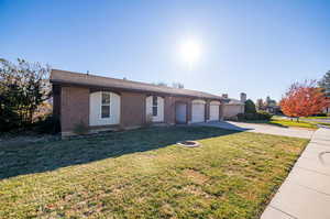 Ranch-style house with a garage and a front lawn