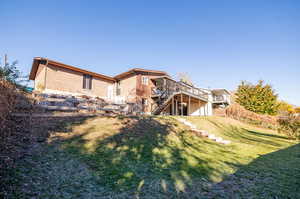 Back of property featuring a deck and a yard