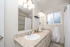 Bathroom with backsplash, vanity, a shower with shower curtain, and tile patterned floors