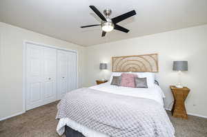 Primary Carpeted bedroom featuring a closet, a textured ceiling, and ceiling fan