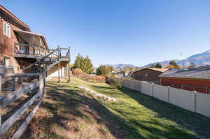 View of yard with a deck with mountain view