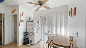 Tiled dining room with ornamental molding and ceiling fan