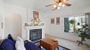 Living room featuring ornamental molding, carpet flooring, and ceiling fan