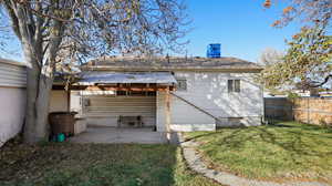 Rear view of property with a lawn and a patio area