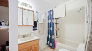 Bathroom featuring vanity and shower / bathtub combination with curtain