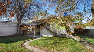 Back of property featuring a lawn and a patio