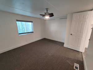 Carpeted empty room featuring ceiling fan