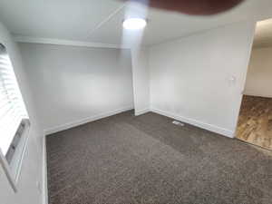 Spare room with dark colored carpet