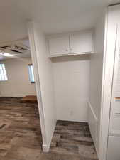 Laundry area featuring dark wood-type flooring and a wealth of natural light