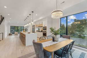 Dining room with a wealth of natural light, an inviting chandelier, and light hardwood / wood-style floors