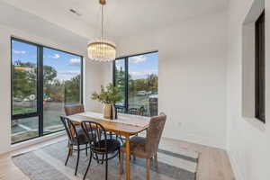 Dining space with a chandelier and light hardwood / wood-style flooring