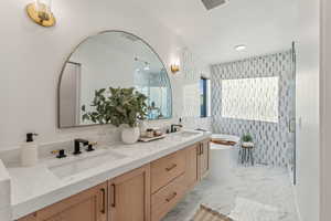 Bathroom featuring vanity and independent shower and bath