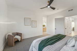 Carpeted bedroom with ceiling fan and ensuite bathroom