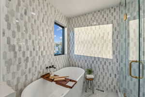 Bathroom featuring tile walls and independent shower and bath