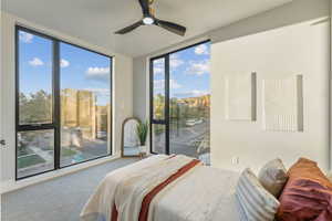 Bedroom with ceiling fan, access to exterior, and multiple windows