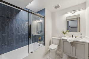 Full bathroom featuring bath / shower combo with glass door, vanity, and toilet