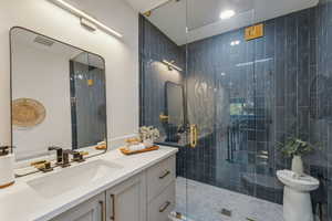 Bathroom featuring an enclosed shower and vanity