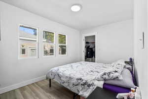 Bedroom with a closet, a walk in closet, and light hardwood / wood-style floors