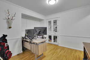 Office space featuring light wood-type flooring and ornamental molding