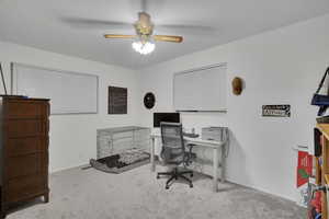 Carpeted home office with ceiling fan