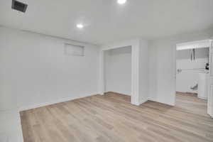 Basement with light wood-type flooring