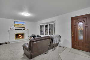 Carpeted living room with a brick fireplace and a textured ceiling