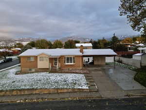 View of front of house with a mountain view and a carport