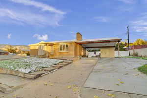 Back of house with a mountain view and a carport