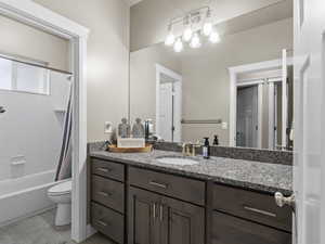 Full bathroom with vanity, tile patterned flooring, toilet, and shower / tub combo