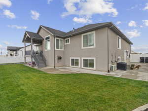 Rear view of house featuring a patio area, a lawn, and cooling unit