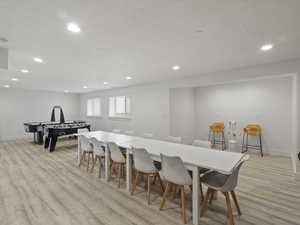 Dining space featuring light wood-type flooring and a textured ceiling