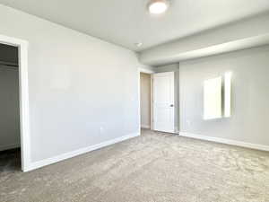 Unfurnished bedroom with carpet floors, a walk in closet, and a closet