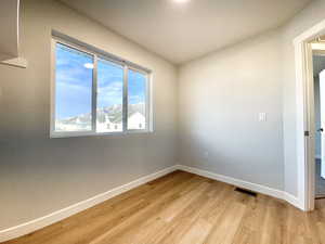 Spare room featuring a mountain view and light hardwood / wood-style flooring