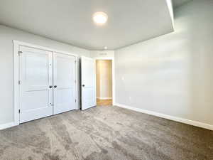 Unfurnished bedroom with carpet and a closet