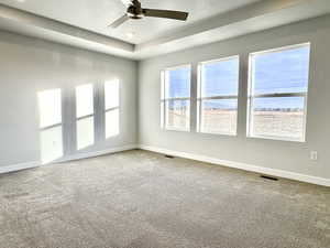 Carpeted spare room with a textured ceiling and ceiling fan