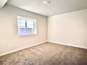 Carpeted empty room with a textured ceiling