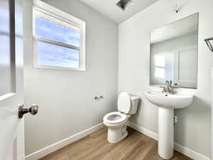 Bathroom featuring hardwood / wood-style floors, a textured ceiling, and toilet