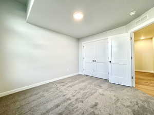 Unfurnished bedroom with a closet and carpet