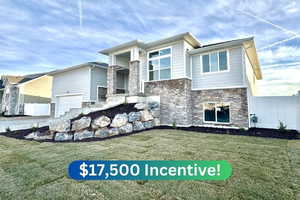 View of front of property featuring a garage and a front yard