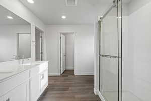 Bathroom with vanity, wood-type flooring, and walk in shower