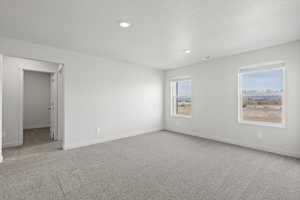 Carpeted spare room featuring a textured ceiling