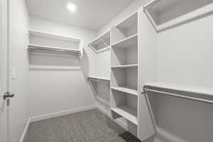 Walk in closet featuring dark colored carpet