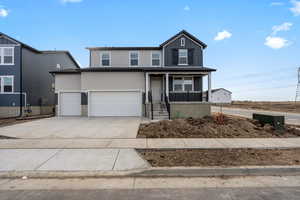 View of property with a porch and a garage