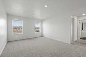 Carpeted spare room featuring a textured ceiling