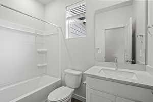 Full bathroom featuring vanity, toilet, and shower / washtub combination