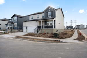 View of front facade featuring a porch and a garage